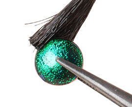 Cabochon in setting being painted with flux